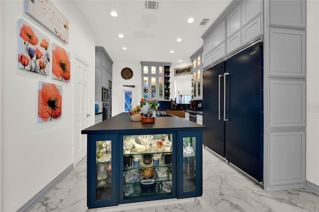 kitchen featuring built in fridge and gray cabinets