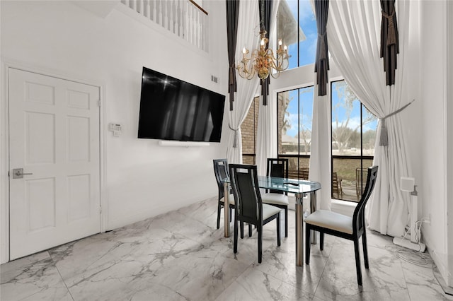 dining area featuring a notable chandelier and a high ceiling