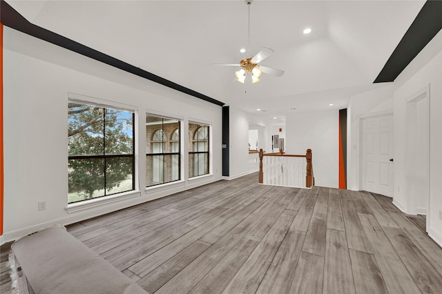 unfurnished living room with light hardwood / wood-style flooring, ceiling fan, and vaulted ceiling