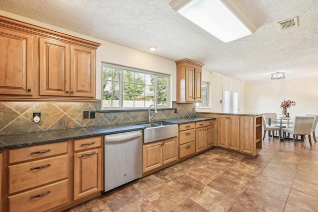 kitchen featuring dishwasher, sink, decorative backsplash, kitchen peninsula, and a textured ceiling