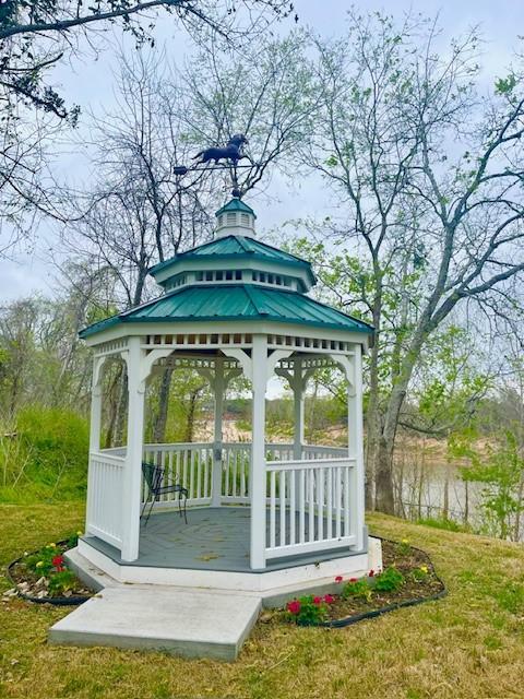 view of home's community with a gazebo, a water view, and a yard