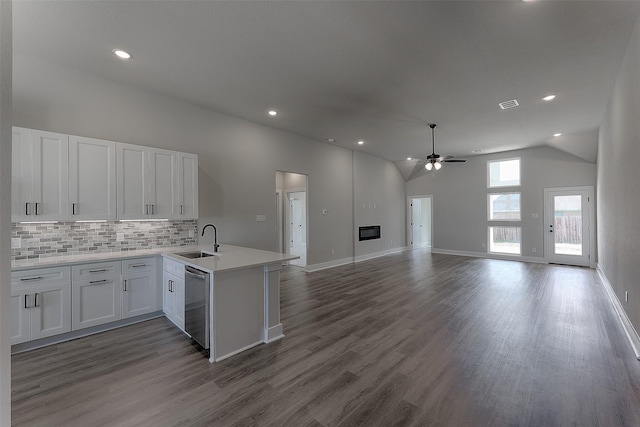 kitchen featuring visible vents, a sink, open floor plan, a peninsula, and dishwasher