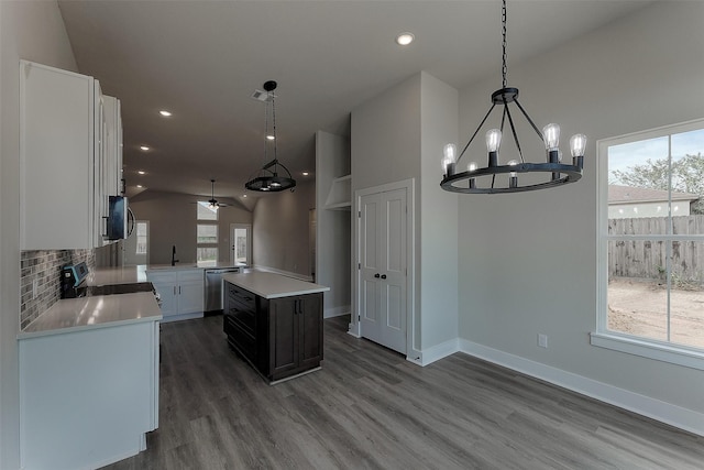 kitchen featuring backsplash, a sink, light countertops, appliances with stainless steel finishes, and a wealth of natural light