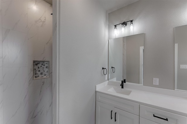 full bathroom with vanity and a marble finish shower