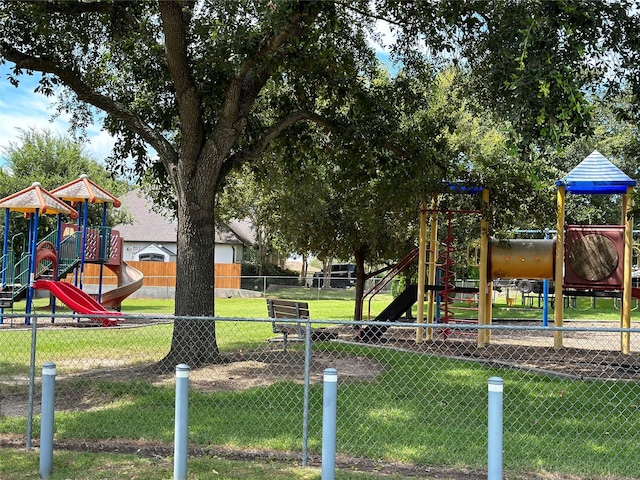 community play area featuring a lawn and fence