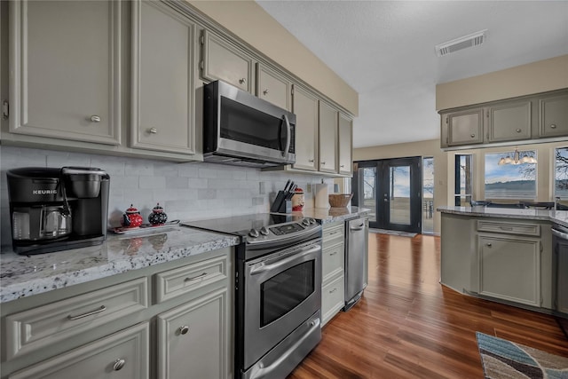 kitchen with stainless steel appliances, decorative backsplash, and gray cabinetry