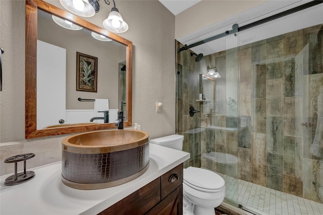 bathroom featuring vanity, toilet, and an enclosed shower