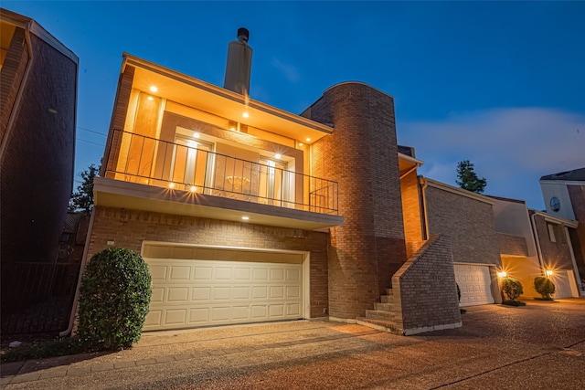 5614 San Felipe St Unit G, Houston, TX 77056 - view of front of home with a balcony, a chimney, brick siding, and a garage