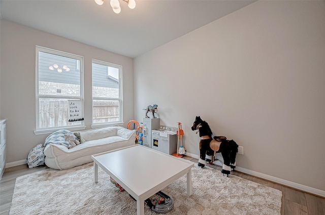 living area with baseboards and wood finished floors