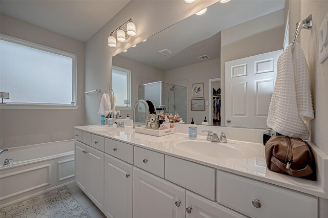 full bath featuring a garden tub, double vanity, visible vents, a sink, and a stall shower