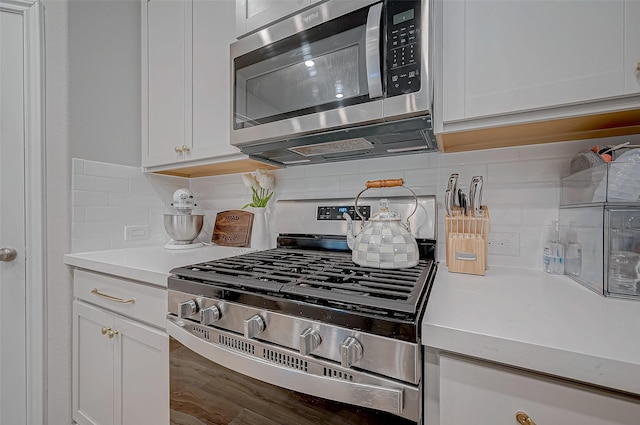 kitchen featuring light countertops, backsplash, white cabinets, and appliances with stainless steel finishes