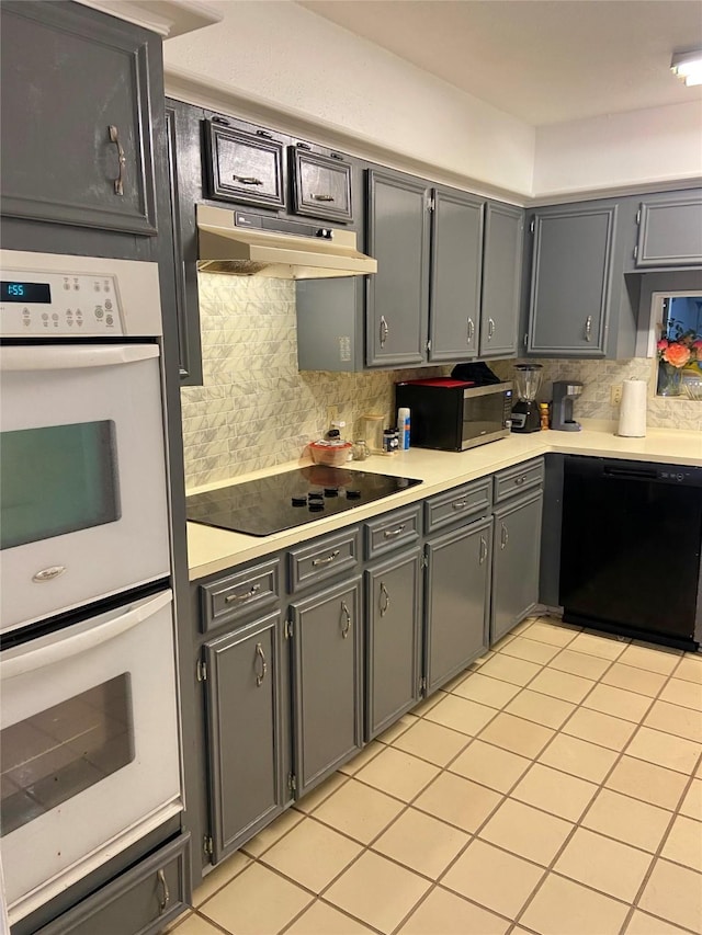 kitchen with tasteful backsplash, gray cabinetry, and black appliances