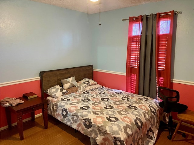 bedroom featuring hardwood / wood-style floors and a textured ceiling