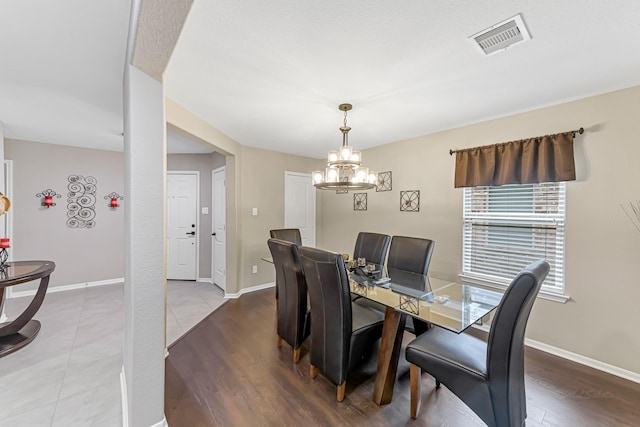 dining space featuring hardwood / wood-style floors and a notable chandelier