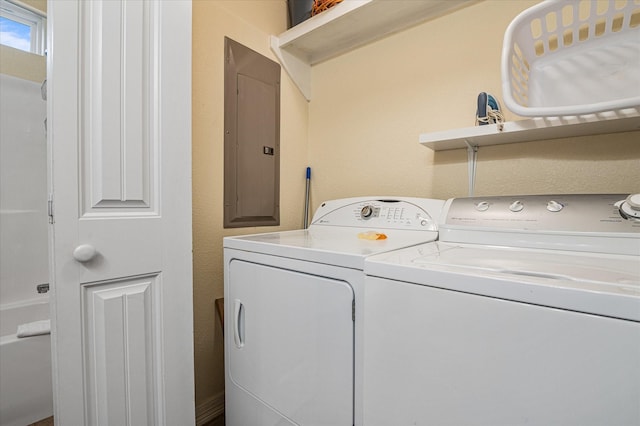 laundry room featuring electric panel and washer and clothes dryer