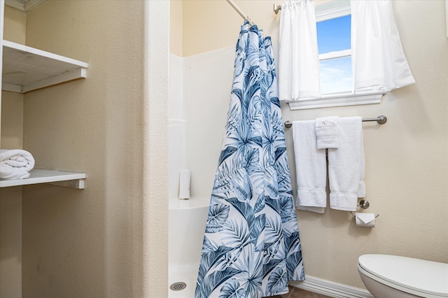 bathroom with a shower with curtain and toilet