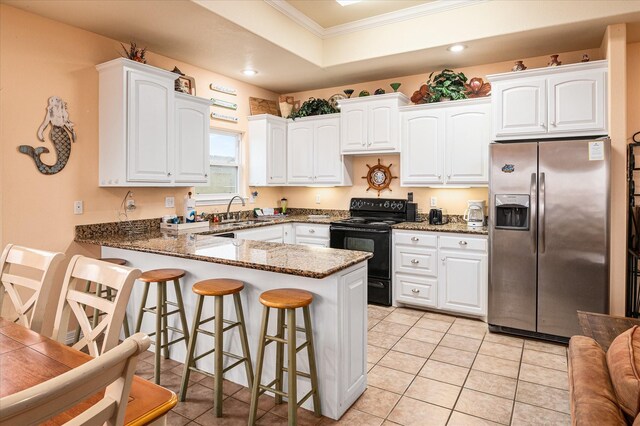 kitchen with black range with electric stovetop, white cabinets, dark stone counters, kitchen peninsula, and stainless steel refrigerator with ice dispenser