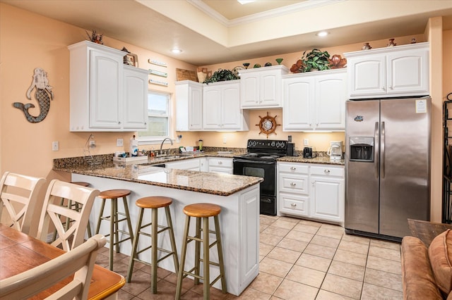 kitchen featuring dark stone countertops, stainless steel refrigerator with ice dispenser, black range with electric cooktop, white cabinetry, and kitchen peninsula