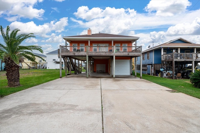 view of front of home featuring covered porch, a garage, and a front lawn