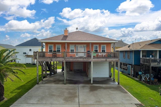 back of house featuring a deck, a garage, and a lawn