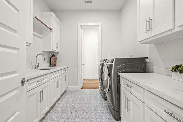 laundry room with washer and dryer, sink, and cabinets