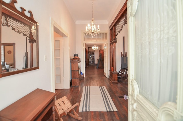 hall featuring an inviting chandelier, dark hardwood / wood-style floors, and crown molding