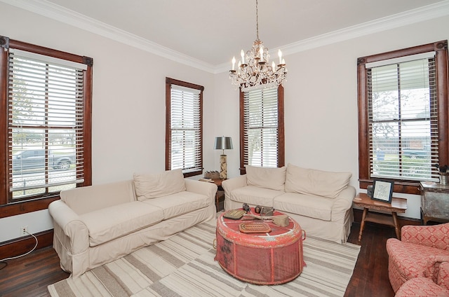 living room featuring hardwood / wood-style flooring, crown molding, and an inviting chandelier