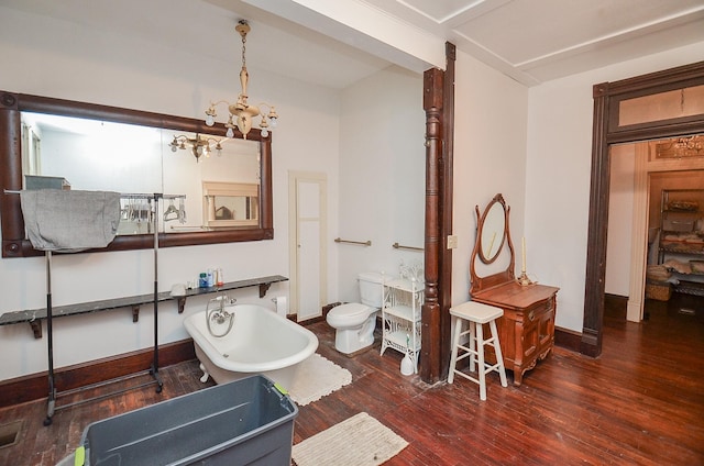 bathroom with a notable chandelier, wood-type flooring, toilet, and a tub