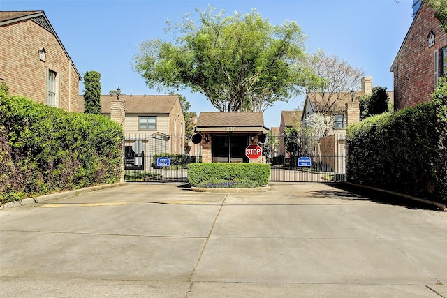 view of front facade featuring a gate and brick siding