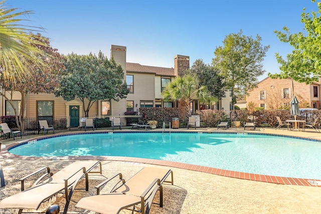 pool featuring a patio area and fence