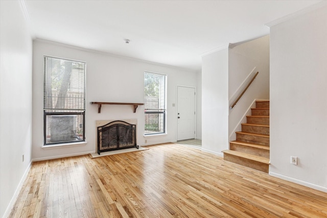 unfurnished living room featuring ornamental molding and light wood-type flooring