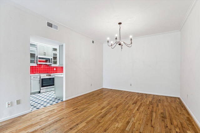 unfurnished dining area with light wood finished floors, visible vents, an inviting chandelier, ornamental molding, and baseboards