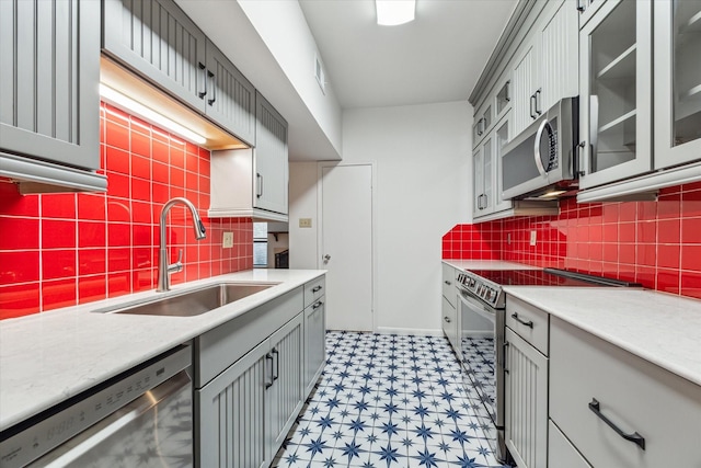 kitchen with stainless steel appliances, tasteful backsplash, sink, and gray cabinetry