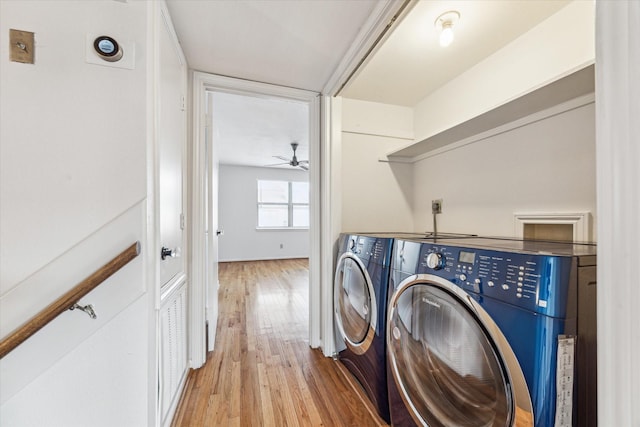 clothes washing area featuring laundry area, washing machine and clothes dryer, and light wood-style flooring