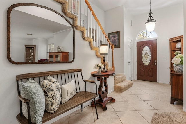 foyer with light tile patterned floors, crown molding, and a wealth of natural light