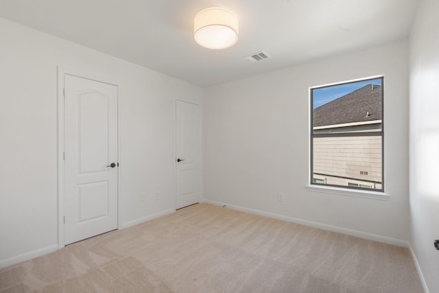 spare room featuring light colored carpet