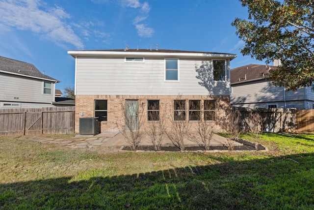 back of property with central AC, a patio area, and a lawn