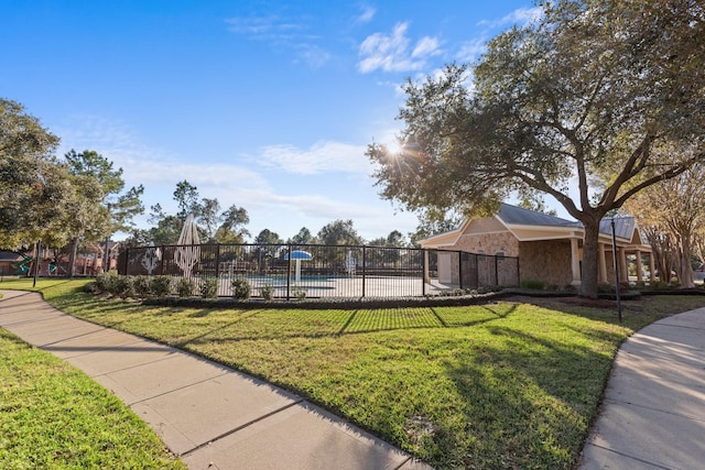 surrounding community featuring a swimming pool and a lawn