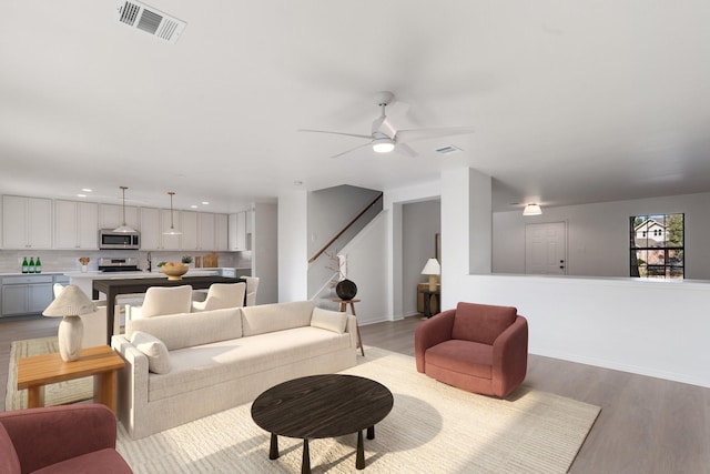 living room featuring ceiling fan and light wood-type flooring