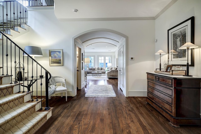 foyer entrance with crown molding and dark hardwood / wood-style flooring