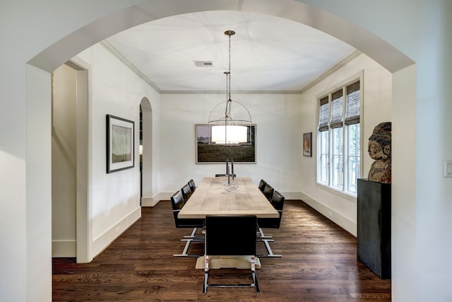 dining space with ornamental molding and dark hardwood / wood-style flooring