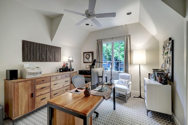 carpeted home office featuring lofted ceiling and ceiling fan