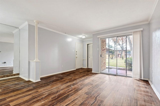 spare room featuring crown molding, dark hardwood / wood-style floors, and decorative columns