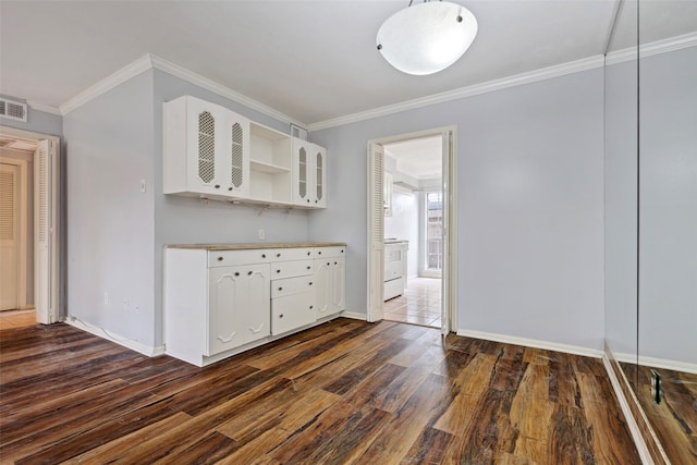 kitchen with crown molding, dark wood-type flooring, and white cabinets