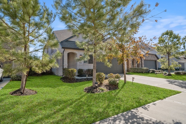 view of front of house with a garage and a front lawn