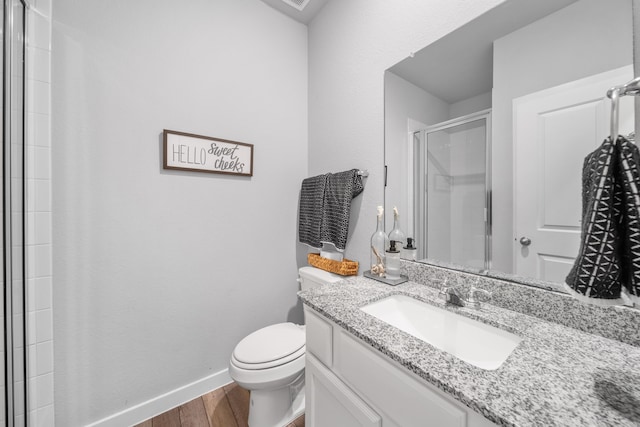 bathroom with vanity, hardwood / wood-style floors, toilet, and an enclosed shower