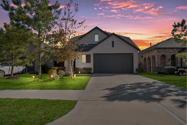 view of front of home with a garage and a yard