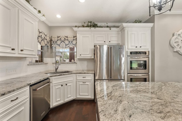 kitchen featuring appliances with stainless steel finishes, sink, white cabinets, backsplash, and ornamental molding