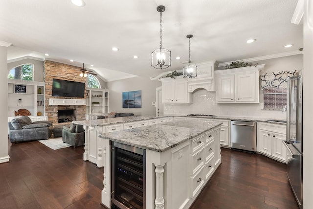 kitchen with stainless steel appliances, wine cooler, a kitchen island, decorative light fixtures, and kitchen peninsula