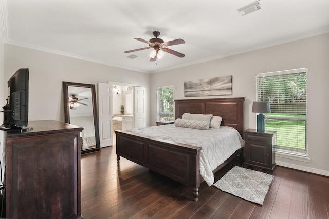 bedroom with multiple windows, crown molding, dark wood-type flooring, and ensuite bath